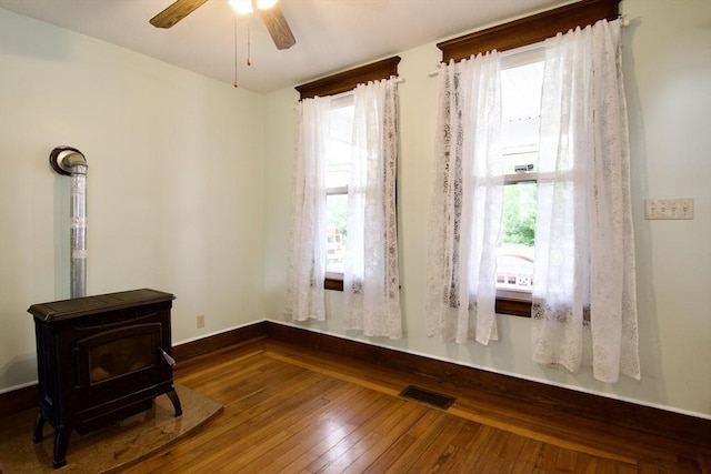 82 Worcester St, West Springfield, MA 01089 - empty room with a wood stove, healthy amount of natural light, and wood-type flooring