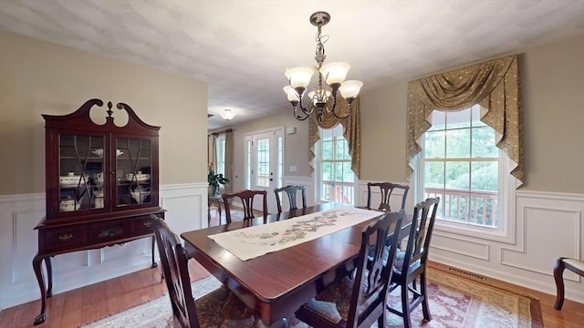 659 Sherman Farm Rd, Burrillville, RI 02830 - dining space with a decorative wall, a wainscoted wall, a chandelier, and wood finished floors