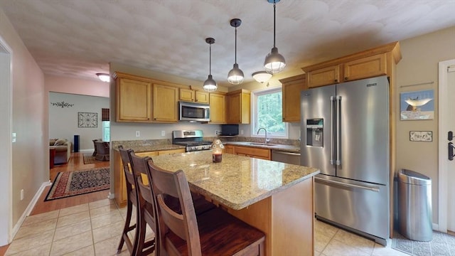 659 Sherman Farm Rd, Burrillville, RI 02830 - kitchen featuring appliances with stainless steel finishes, a sink, light stone countertops, a center island, and a kitchen breakfast bar