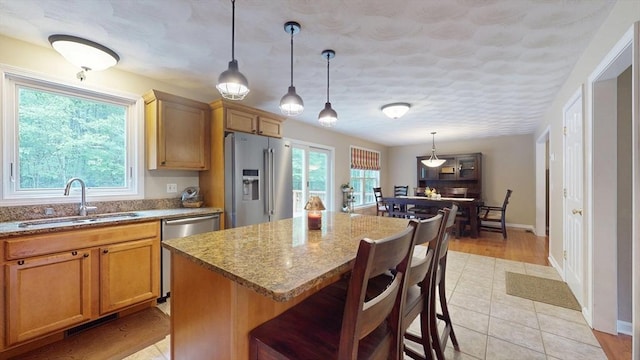 659 Sherman Farm Rd, Burrillville, RI 02830 - kitchen featuring appliances with stainless steel finishes, a sink, light stone counters, and a kitchen breakfast bar
