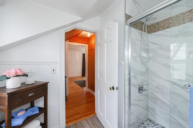 bathroom with a shower with door and wood-type flooring