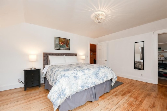 bedroom featuring a notable chandelier and light hardwood / wood-style flooring