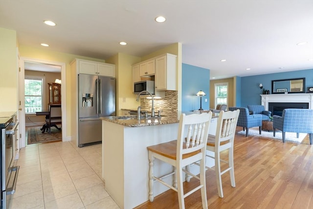 9 Old Poor Farm Rd, Ware, MA 01082 - kitchen featuring appliances with stainless steel finishes, white cabinets, stone counters, recessed lighting, and a peninsula