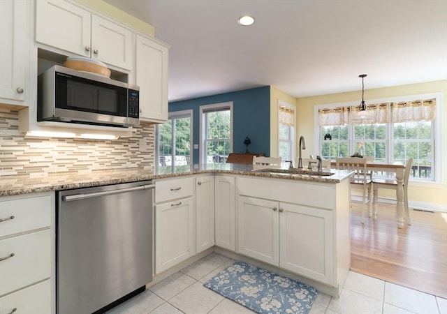 9 Old Poor Farm Rd, Ware, MA 01082 - kitchen with appliances with stainless steel finishes, light tile patterned floors, a peninsula, decorative backsplash, and white cabinets