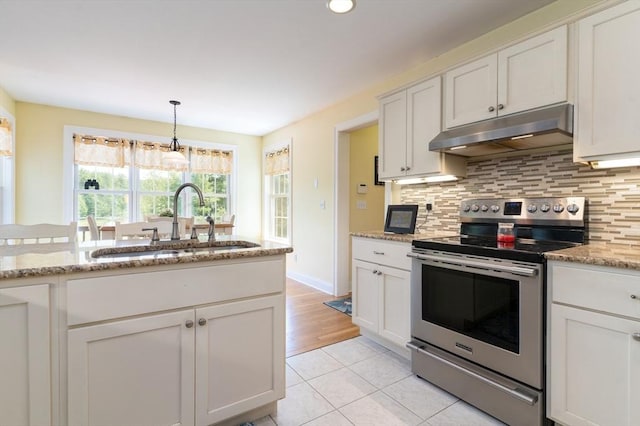 9 Old Poor Farm Rd, Ware, MA 01082 - kitchen with stainless steel electric range, under cabinet range hood, decorative backsplash, light tile patterned floors, and hanging light fixtures