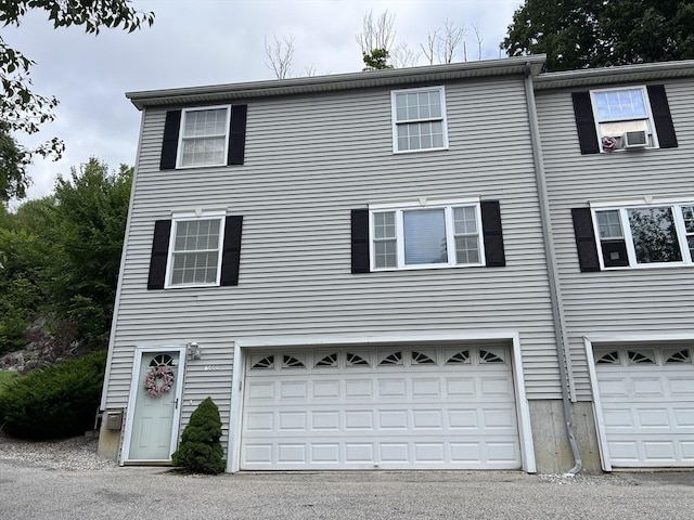 view of front of property with a garage and cooling unit