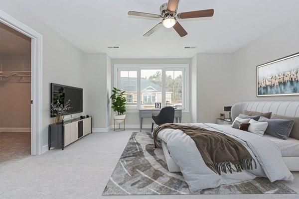 carpeted bedroom featuring a spacious closet, a closet, and ceiling fan