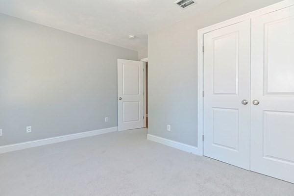 unfurnished bedroom featuring a closet and light colored carpet