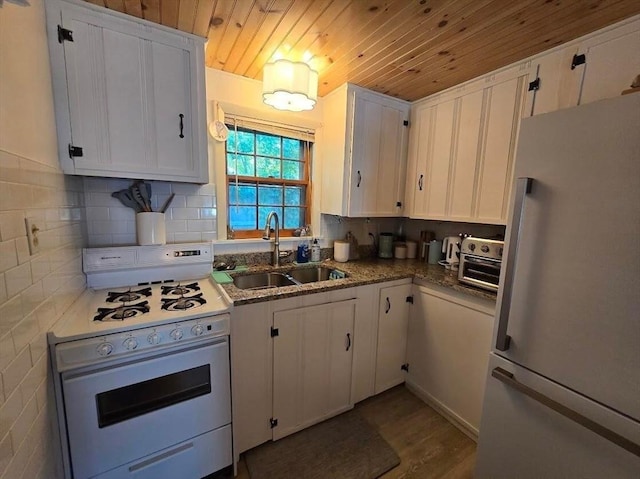 kitchen with wooden ceiling, white appliances, white cabinetry, and a sink