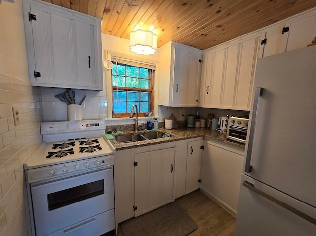 kitchen with decorative backsplash, white cabinets, white appliances, sink, and dark wood-type flooring