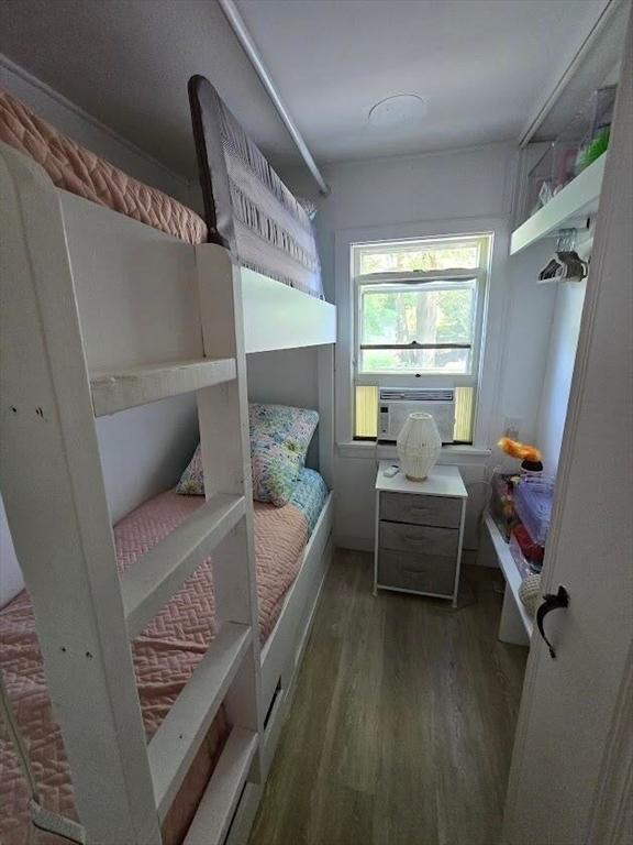 bedroom with wood finished floors and cooling unit