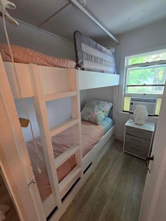 bedroom with wood finished floors and cooling unit