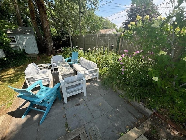 view of patio featuring an outdoor structure, an outdoor hangout area, a storage unit, and fence