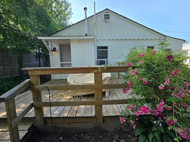 back of property with fence and a wooden deck