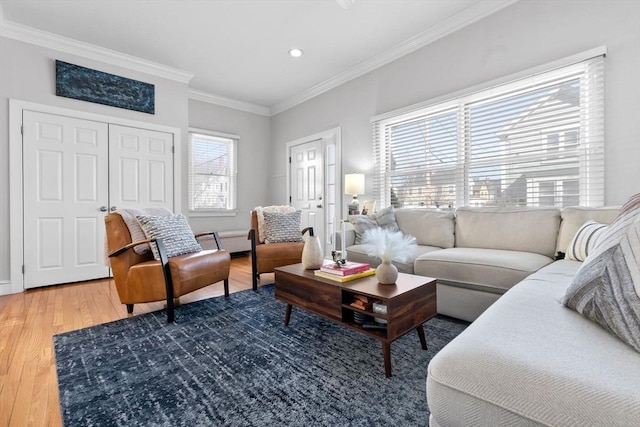 living room with crown molding, light wood-style floors, and baseboards