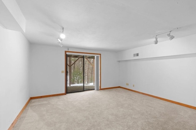 unfurnished room with light colored carpet and track lighting