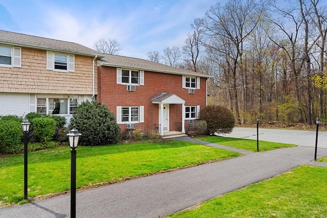 view of front of house featuring brick siding and a front yard