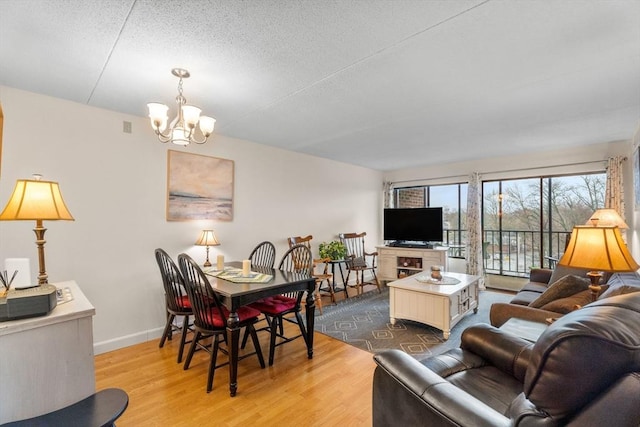 49 Melrose St Unit 4E, Melrose, MA 02176 - living area with a chandelier, wood finished floors, baseboards, and a textured ceiling