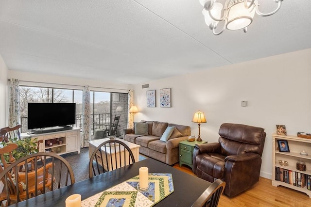 49 Melrose St Unit 4E, Melrose, MA 02176 - living room featuring a chandelier, wood finished floors, a textured ceiling, and baseboards