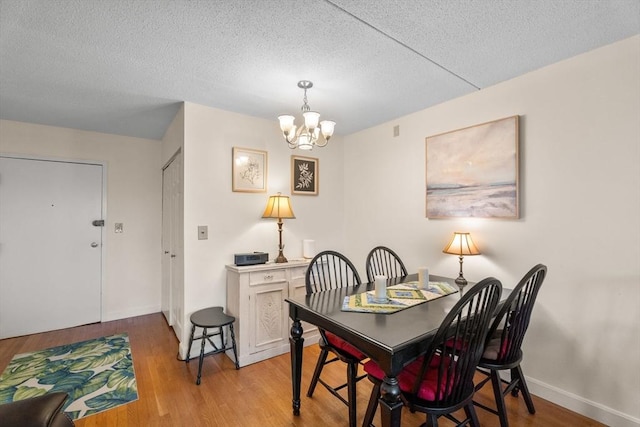 49 Melrose St Unit 4E, Melrose, MA 02176 - dining space with a chandelier, a textured ceiling, light wood-style flooring, and baseboards