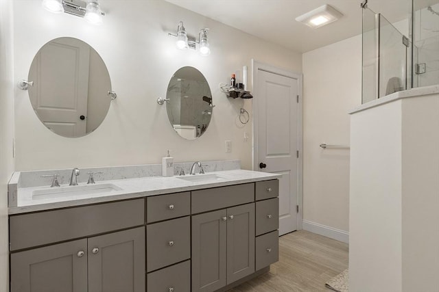 bathroom with hardwood / wood-style flooring, vanity, and walk in shower