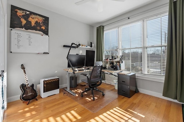 office space featuring ceiling fan, a healthy amount of sunlight, heating unit, and light wood-type flooring