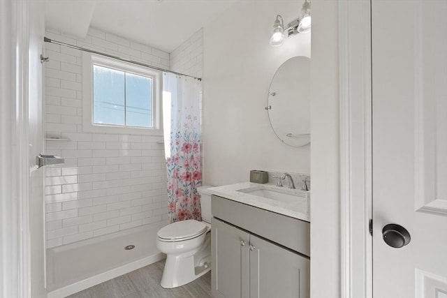 bathroom featuring walk in shower, vanity, toilet, and wood-type flooring