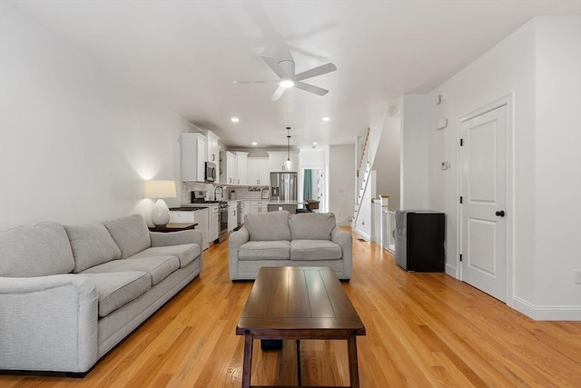 living room featuring ceiling fan and light wood-type flooring