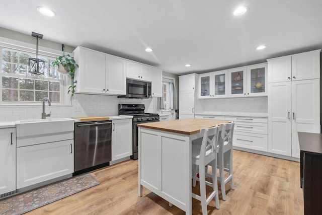 kitchen featuring pendant lighting, stainless steel appliances, and white cabinets