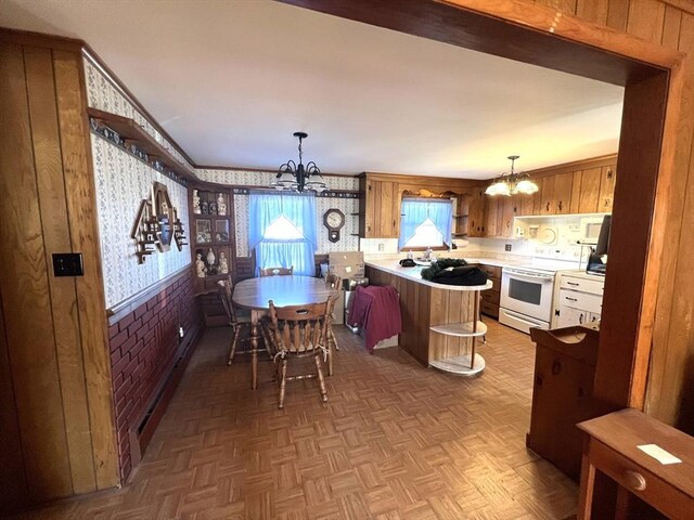 kitchen featuring a chandelier, white electric stove, a peninsula, a baseboard radiator, and wallpapered walls