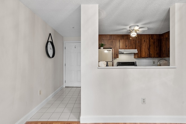 kitchen featuring stainless steel fridge, decorative backsplash, a textured ceiling, and ceiling fan