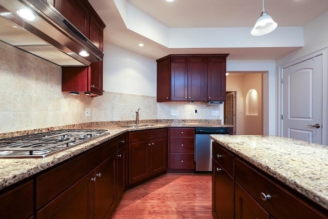 kitchen with sink, wall chimney exhaust hood, hanging light fixtures, stainless steel appliances, and dark hardwood / wood-style flooring