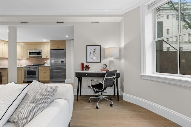 407 Shawmut Ave Unit 1, Boston, MA 02118 - bedroom with stainless steel fridge, multiple windows, light wood finished floors, an office area, and crown molding
