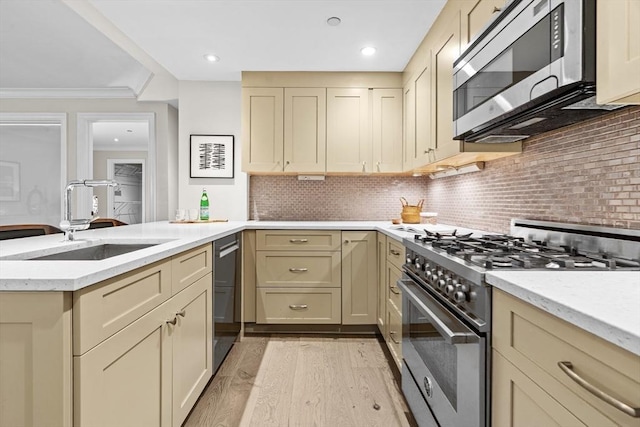 407 Shawmut Ave Unit 1, Boston, MA 02118 - kitchen with appliances with stainless steel finishes, cream cabinetry, light wood finished floors, decorative backsplash, and light stone countertops