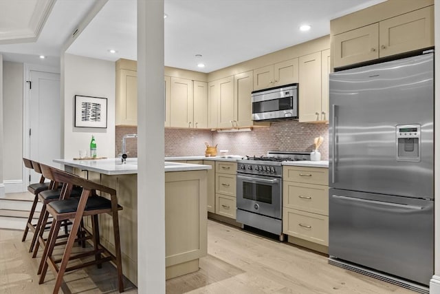 407 Shawmut Ave Unit 1, Boston, MA 02118 - kitchen featuring appliances with stainless steel finishes, light countertops, tasteful backsplash, light wood-type flooring, and recessed lighting