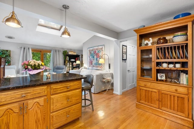 19 Beal Rd, Waltham, MA 02453 - kitchen with lofted ceiling, open floor plan, a skylight, light wood-style floors, and pendant lighting