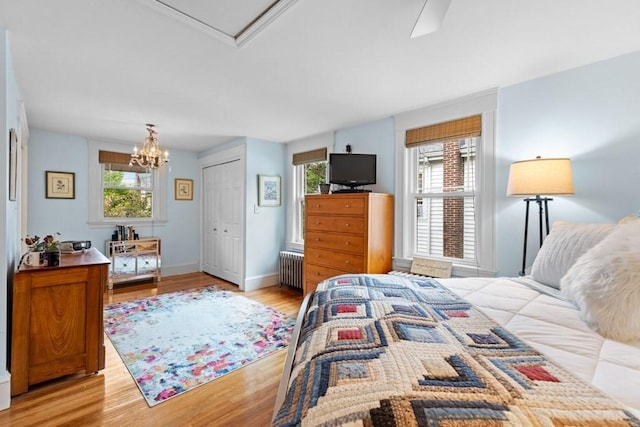 19 Beal Rd, Waltham, MA 02453 - bedroom with radiator, light wood-style floors, a chandelier, a closet, and baseboards