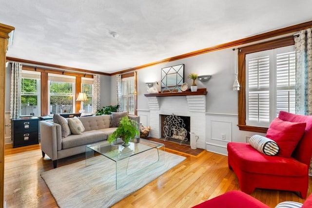 19 Beal Rd, Waltham, MA 02453 - living room featuring ornamental molding, healthy amount of natural light, a brick fireplace, wood finished floors, and a wainscoted wall