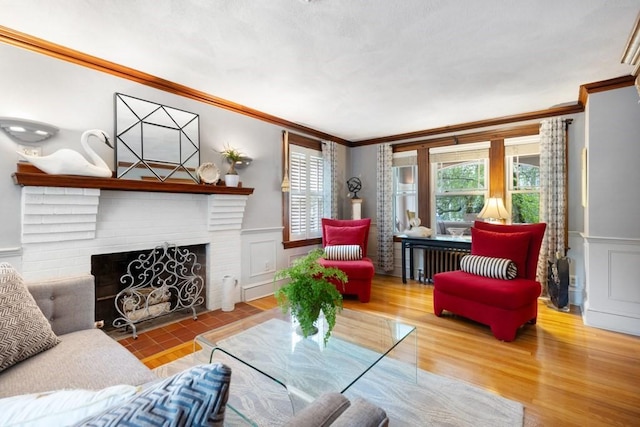 19 Beal Rd, Waltham, MA 02453 - living room with ornamental molding, wainscoting, a brick fireplace, a decorative wall, and wood finished floors