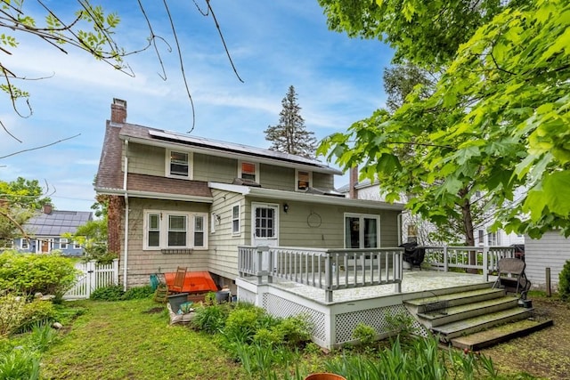 19 Beal Rd, Waltham, MA 02453 - rear view of house with a chimney, a deck, roof mounted solar panels, and roof with shingles