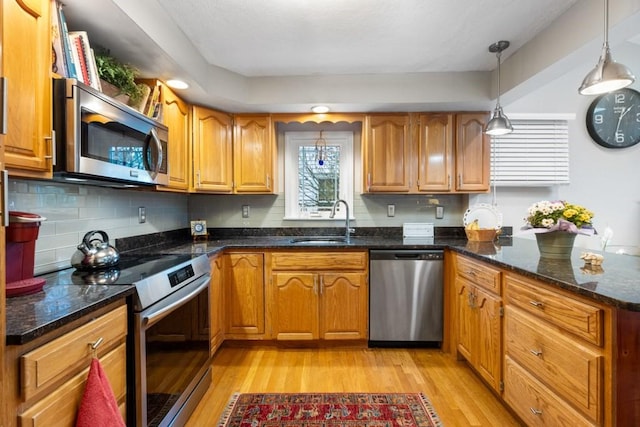 19 Beal Rd, Waltham, MA 02453 - kitchen with stainless steel appliances, a sink, light wood-style flooring, and brown cabinets