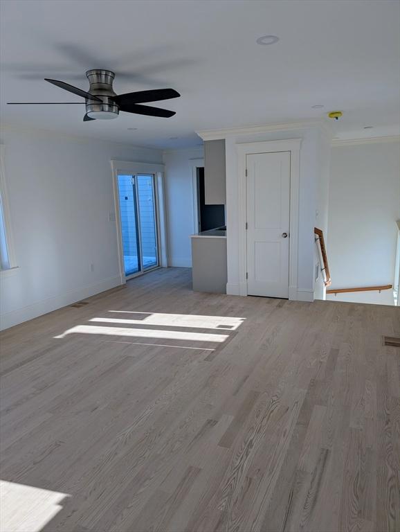 interior space featuring light wood-style floors, baseboards, and ornamental molding