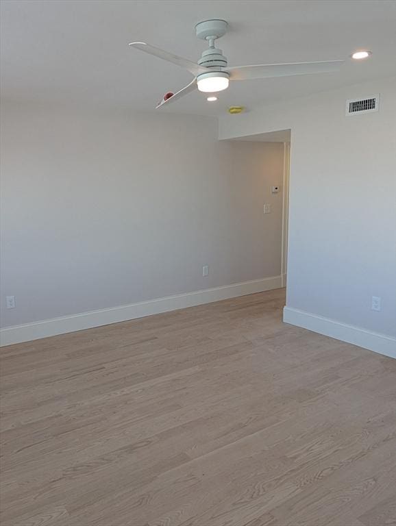 empty room with visible vents, baseboards, ceiling fan, and light wood finished floors