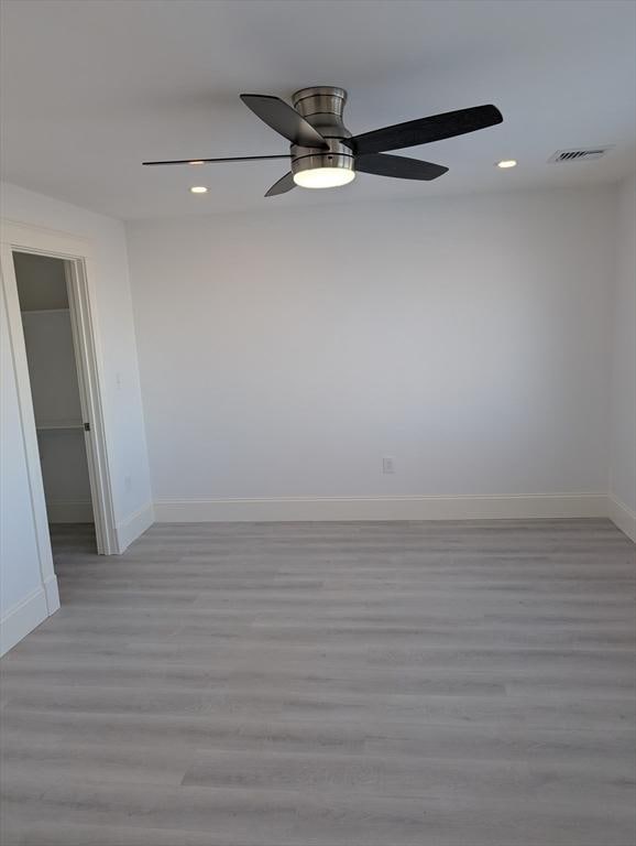 unfurnished room with visible vents, baseboards, recessed lighting, ceiling fan, and light wood-style floors