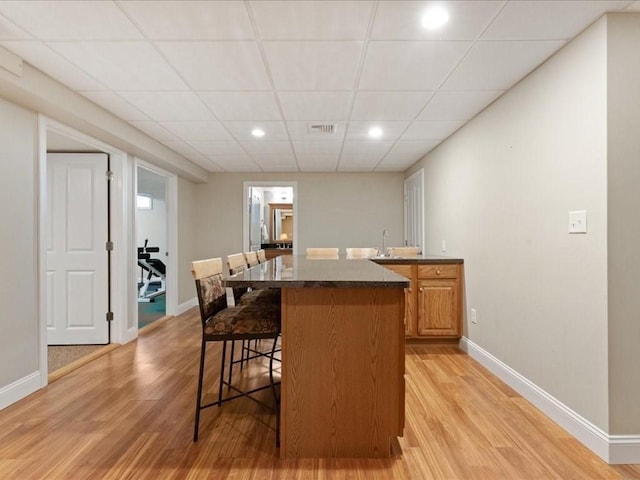 26 Silver Brook Ln Unit 26, Norwell, MA 02061 - kitchen featuring a kitchen breakfast bar, light wood-type flooring, a kitchen island, a drop ceiling, and recessed lighting