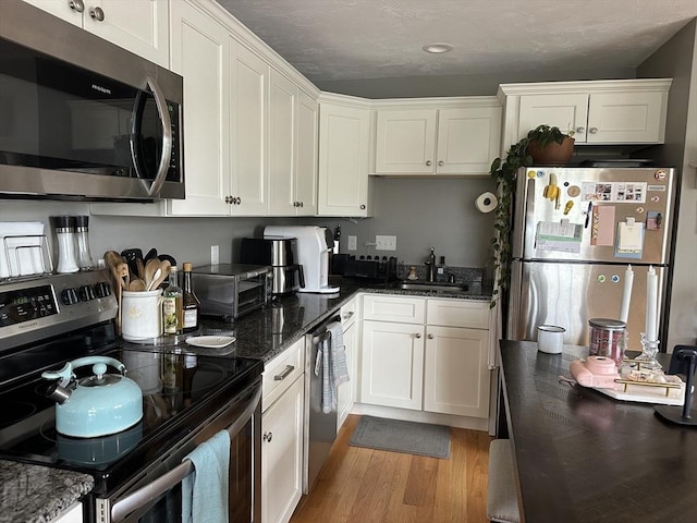 83C Maple Ave Unit C, Rutland, MA 01543 - kitchen with stainless steel appliances, white cabinets, light wood-type flooring, dark stone countertops, and recessed lighting