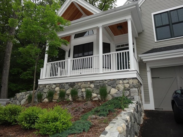 83 Johnson Woods Dr Unit 83, Reading, MA 01867 - view of property exterior featuring covered porch, an attached garage, and stone siding