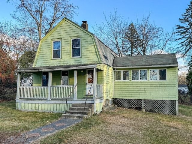 farmhouse with covered porch and a front lawn