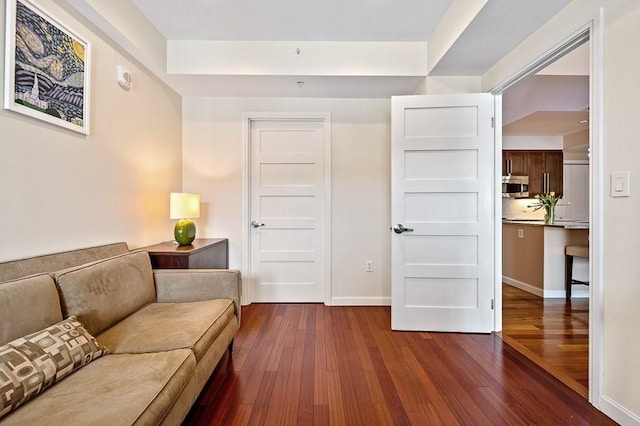 sitting room with dark wood-type flooring