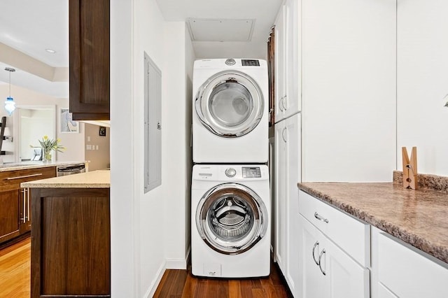 laundry room featuring dark wood-type flooring and stacked washer and clothes dryer